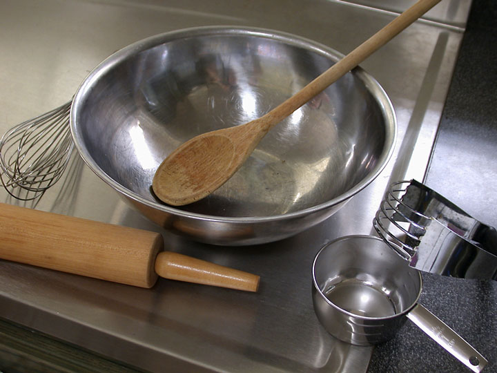 stainless steel bowl and baking utensils on a stainless steel countertop