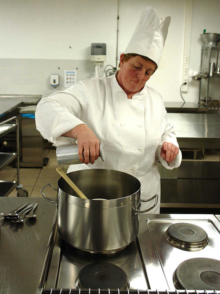 chef working in a commercial kitchen with stainless steel work surfaces